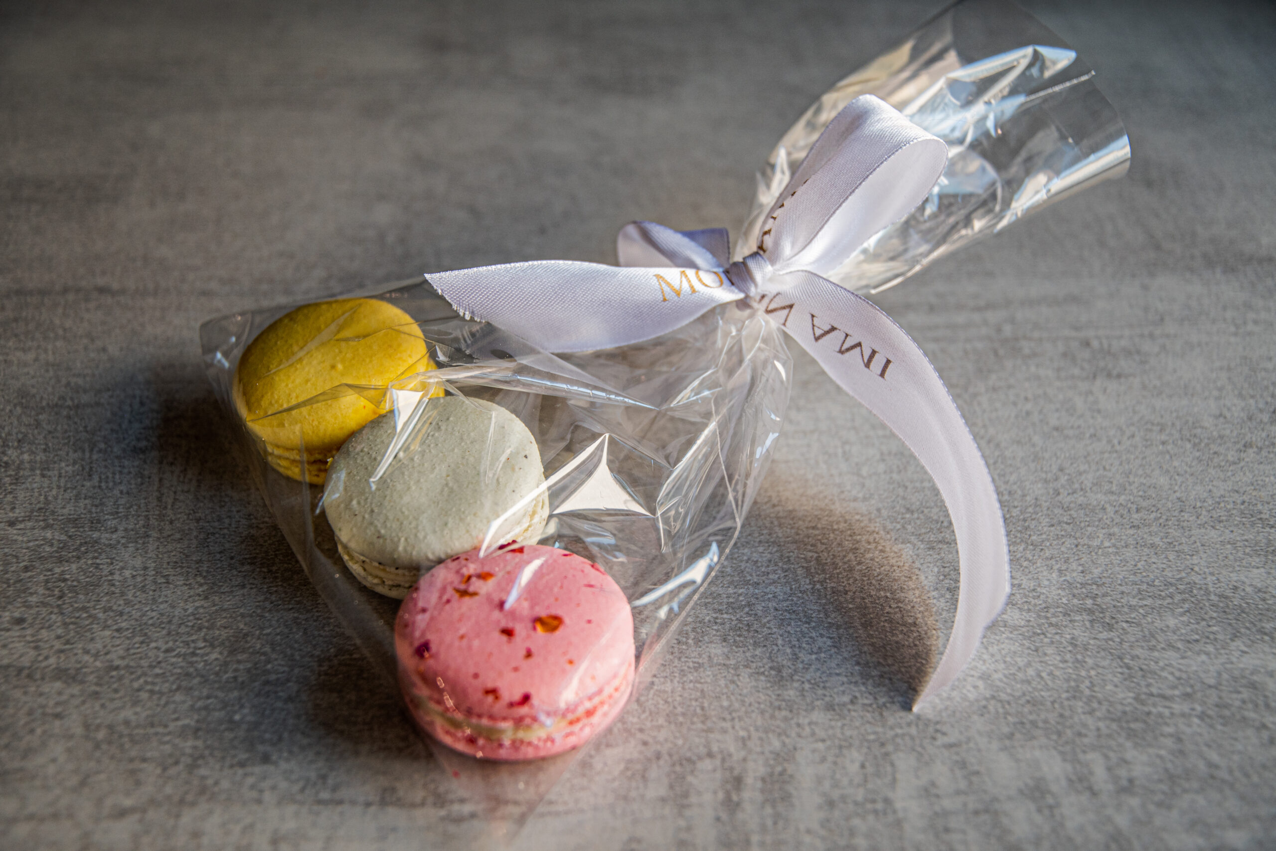 Kolorowe makaroniki zapakowane w torebkę celofanową przewiązaną białą wstążką - sklep.grala.com.pl